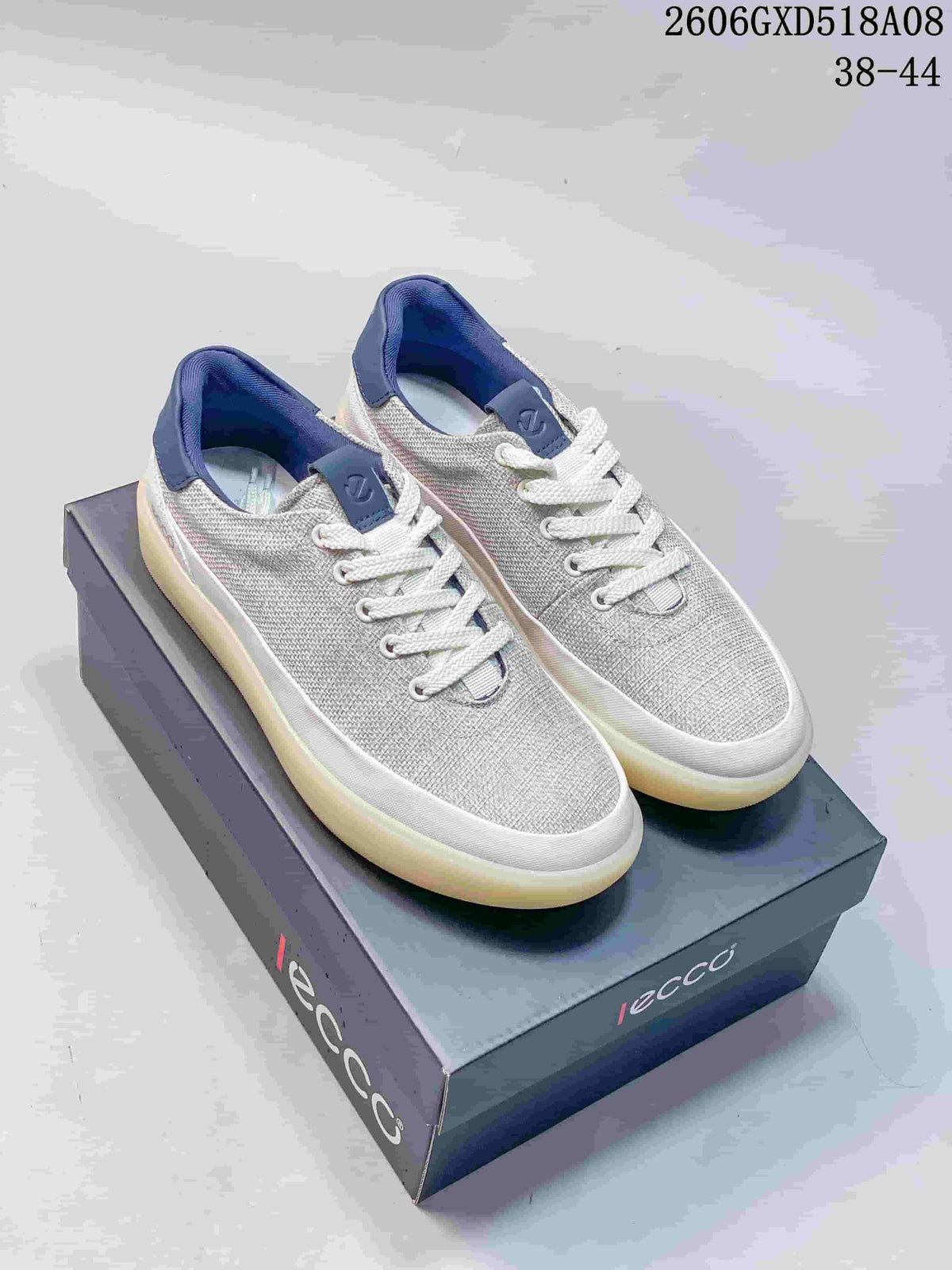 Pair of gray low-top sneakers with white laces, navy accents, and thick pale outsoles.