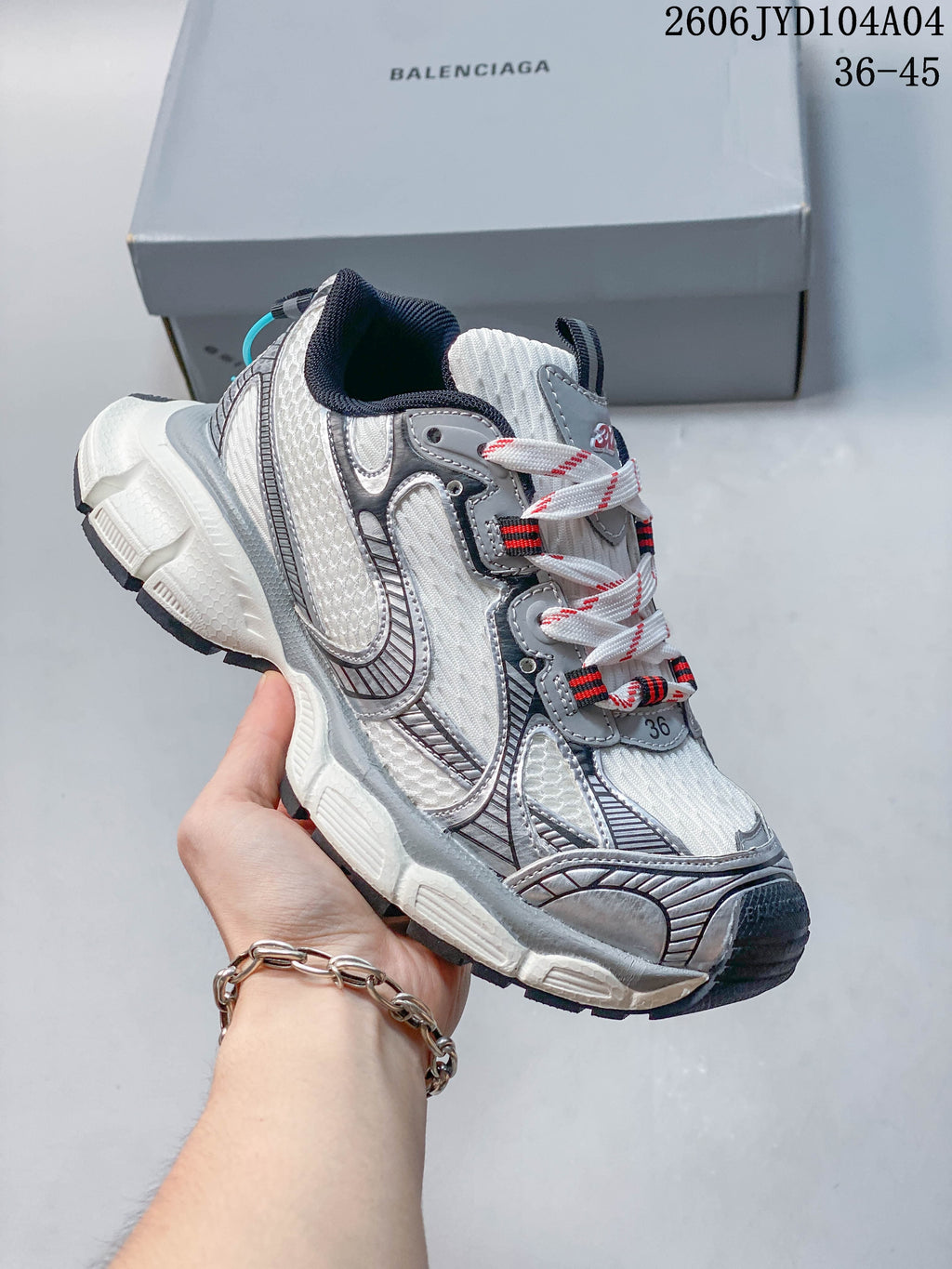 Angled side view of the white and gray sneaker with a sculpted sole