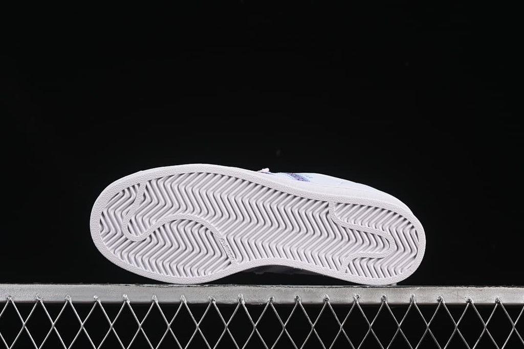 Underside view of the sneaker outsole with a herringbone-style tread pattern