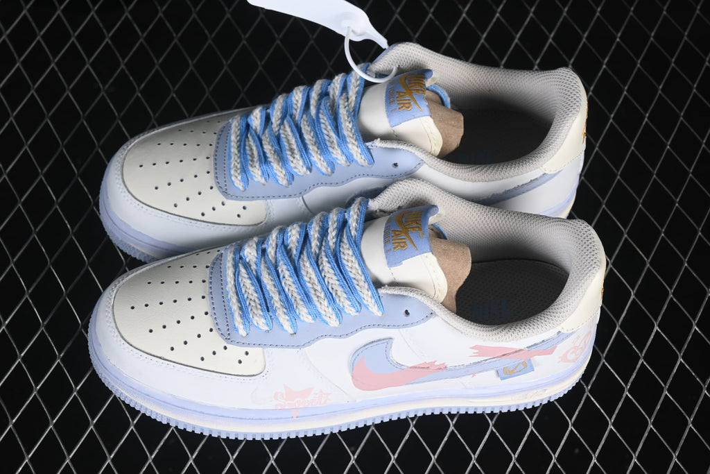 Pair of white and pale blue Nike Air Force 1 '07 low-top sneakers with braided blue-and-cream laces and pink side graphics