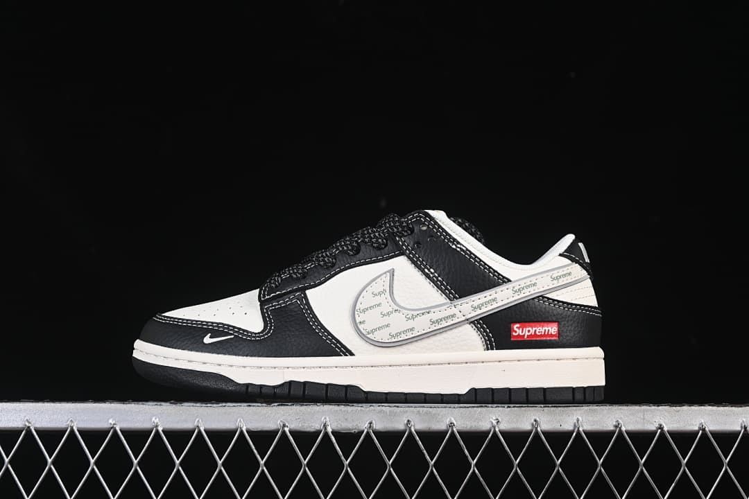 Side view of a black and white Nike SB Dunk Low with a patterned side panel and red Supreme label