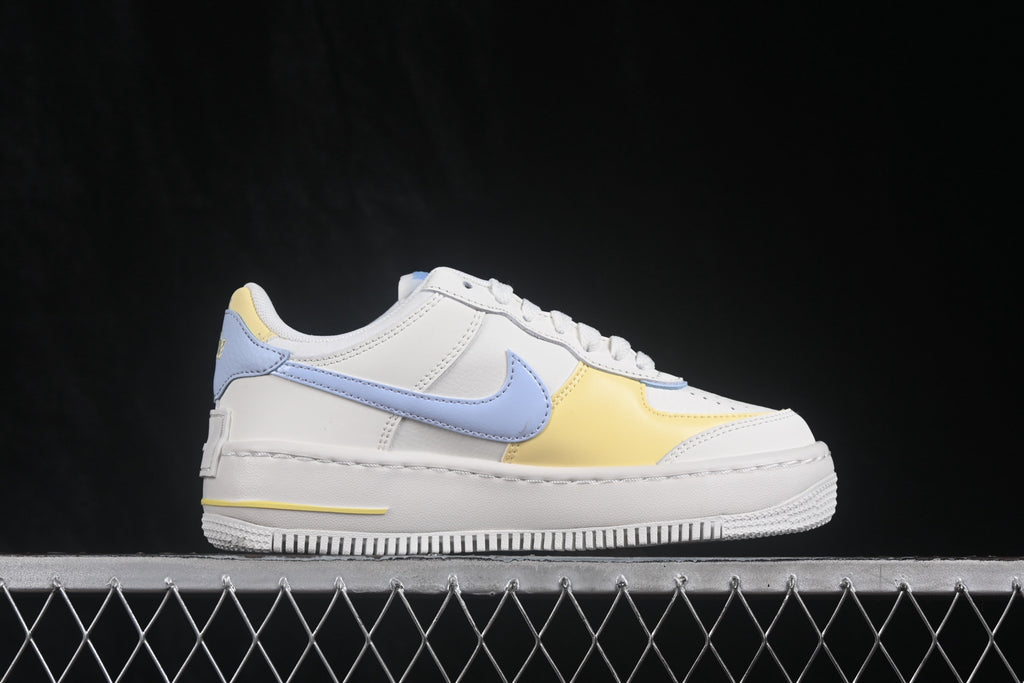 Opposite lateral side view showing the light blue Swoosh, yellow forefoot panel, and white layered sole.