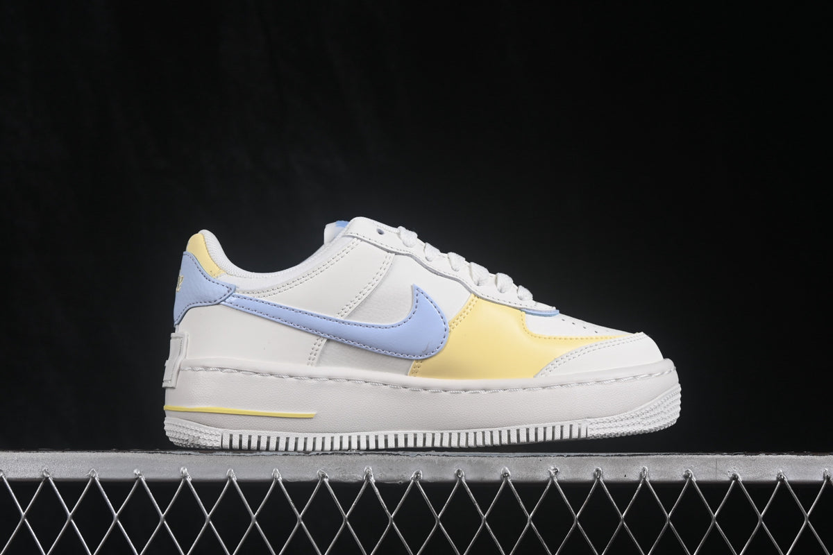 Opposite lateral side view showing the light blue Swoosh, yellow forefoot panel, and white layered sole.