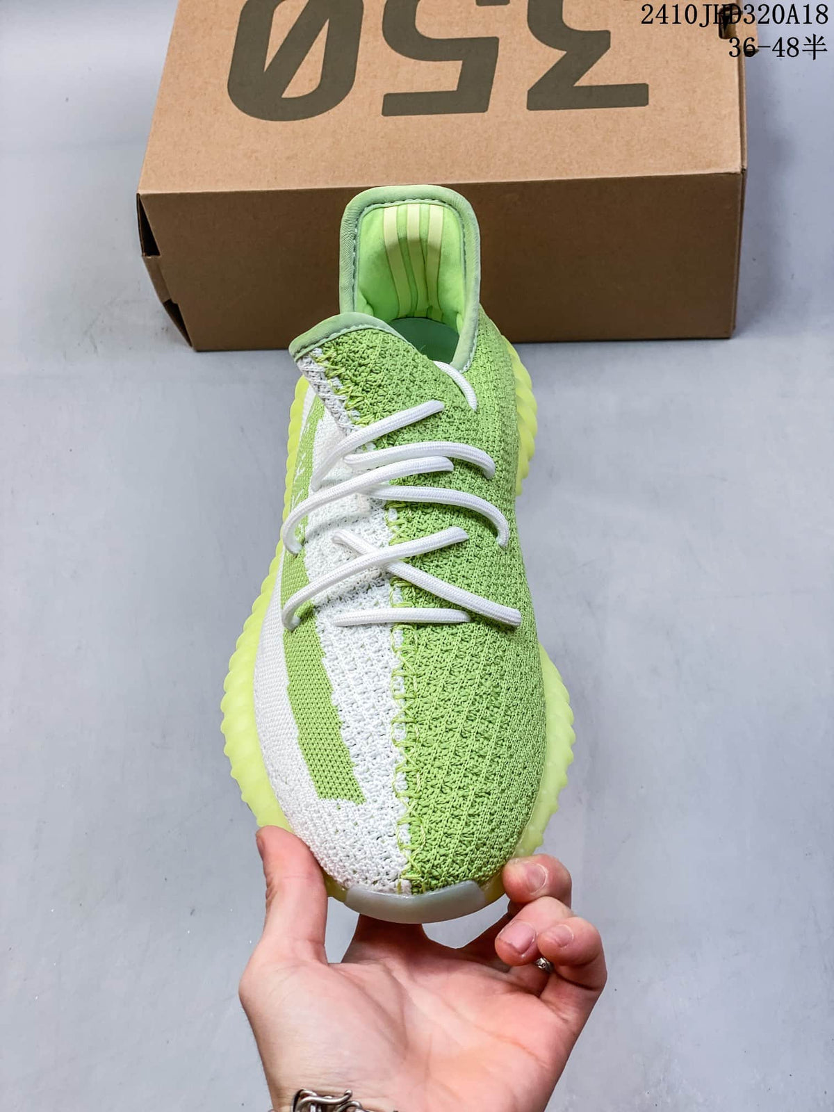 Front view of a green and white lace-up sneaker