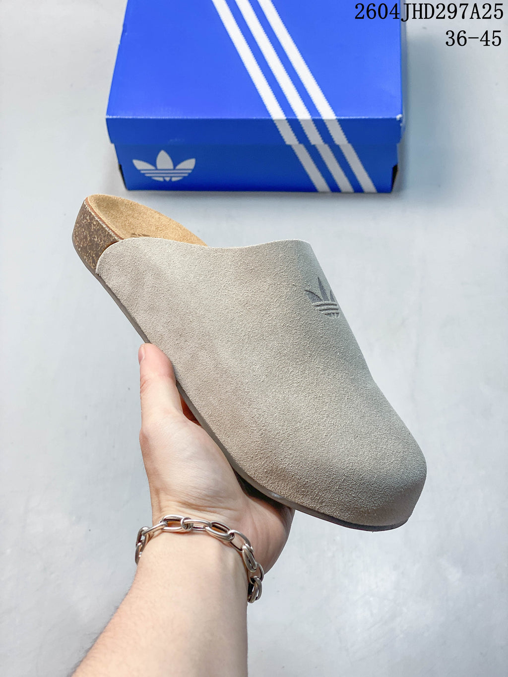 Close-up of a light beige Adidas Adimule mule showing its broad upper and cork-colored footbed