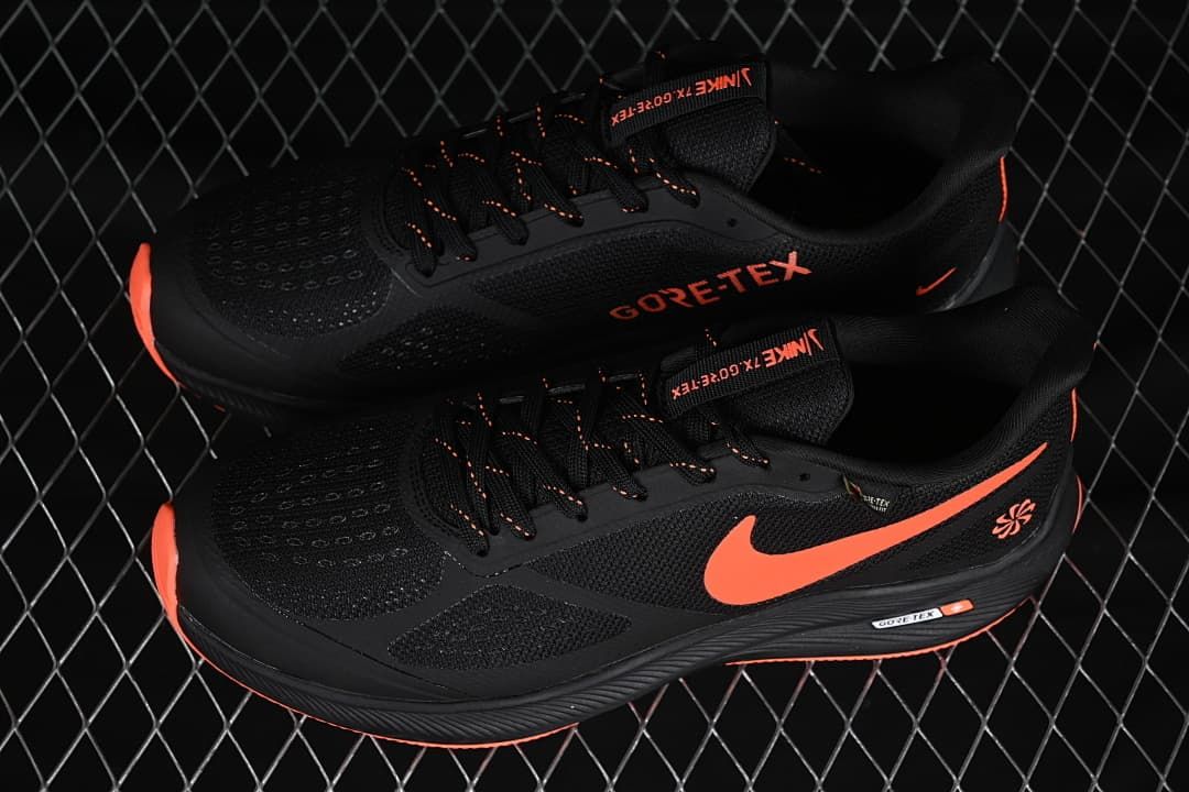 Pair of black Nike running shoes with coral-orange accents, shown from above and the side.