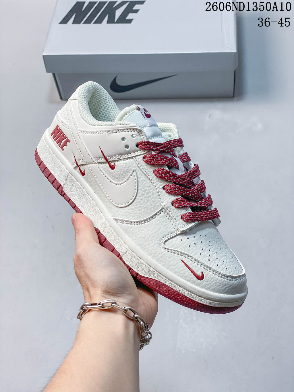 White low-top sneaker with blue laces and blue Swoosh details.