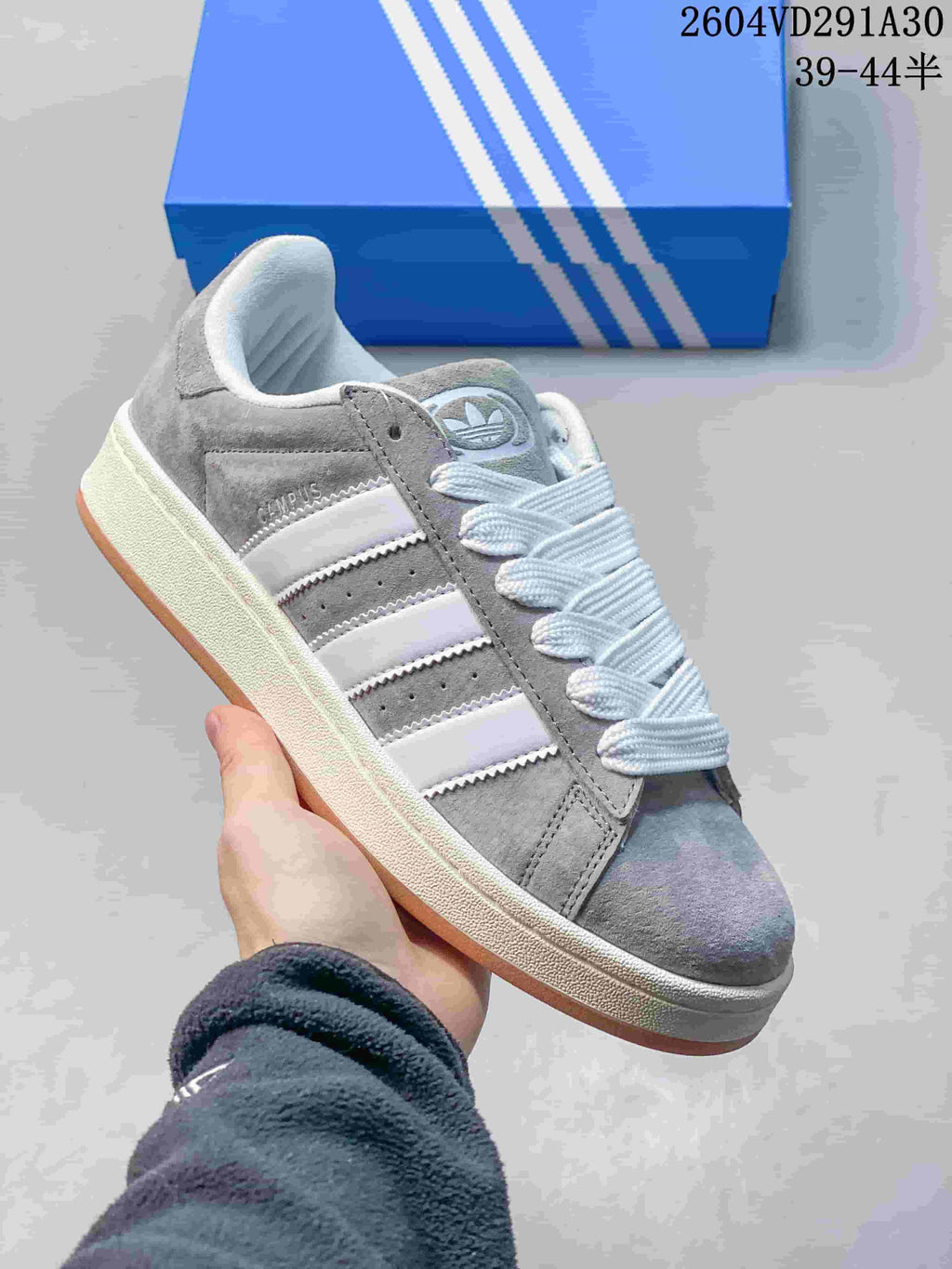 Close side view of the grey Campus sneaker with white stripes