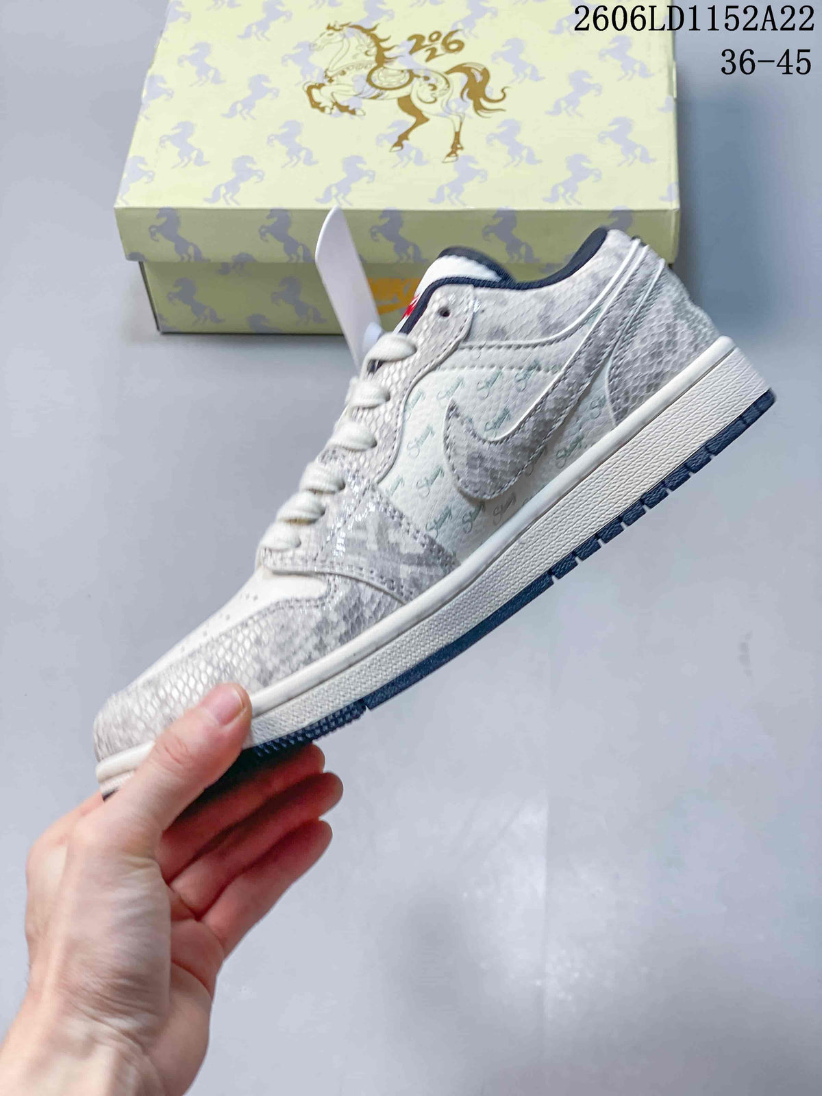 Side profile of a white and grey Jordan Air Jordan 1 Low sneaker with navy outsole and red detailing.
