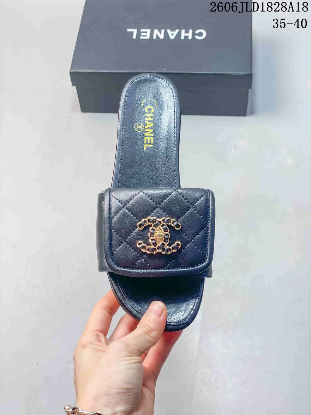 Top view of a navy slide sandal with a quilted strap and gold-tone ornament