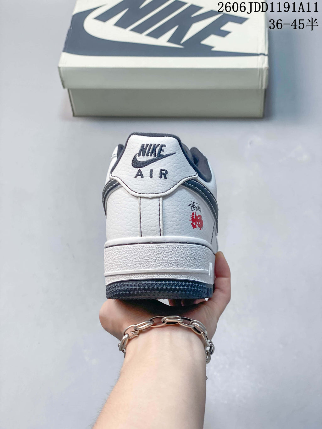 Rear view of the white sneaker with navy trim and heel branding