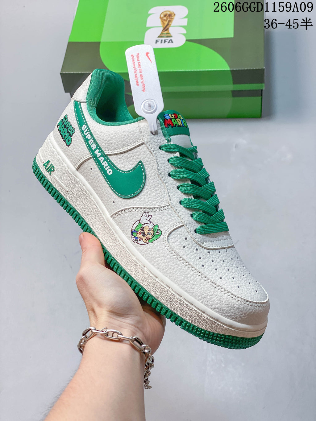 White and green low-top sneaker with Super Mario graphics and green laces