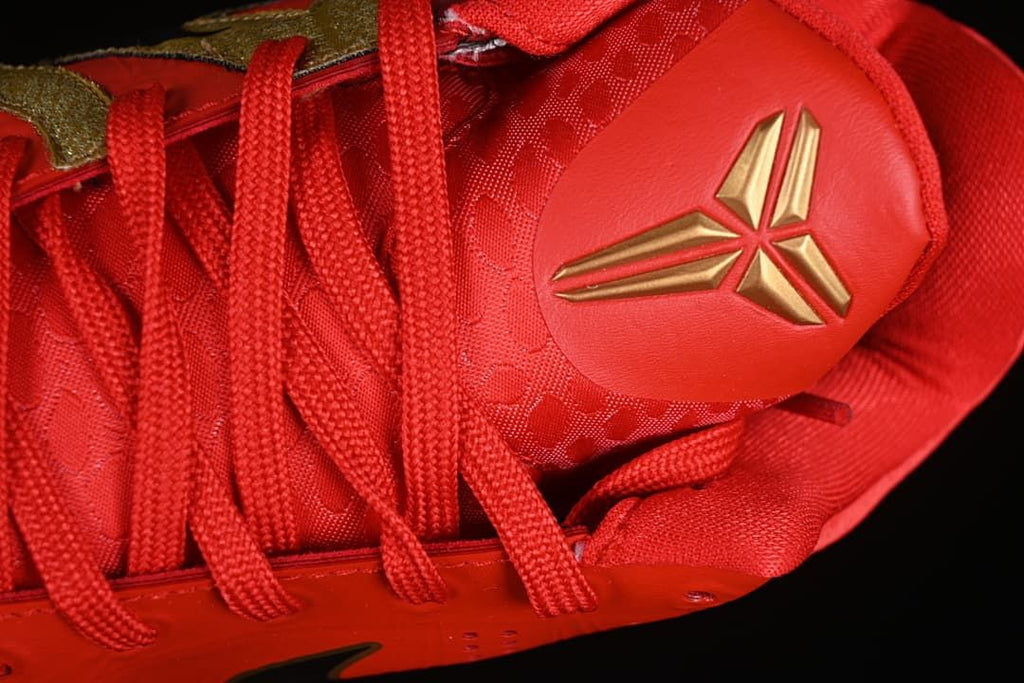 Close-up of red laces and gold basketball-style tongue emblem