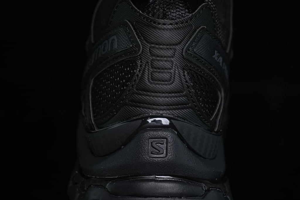 Rear view of the black shoe showing heel details and Salomon branding