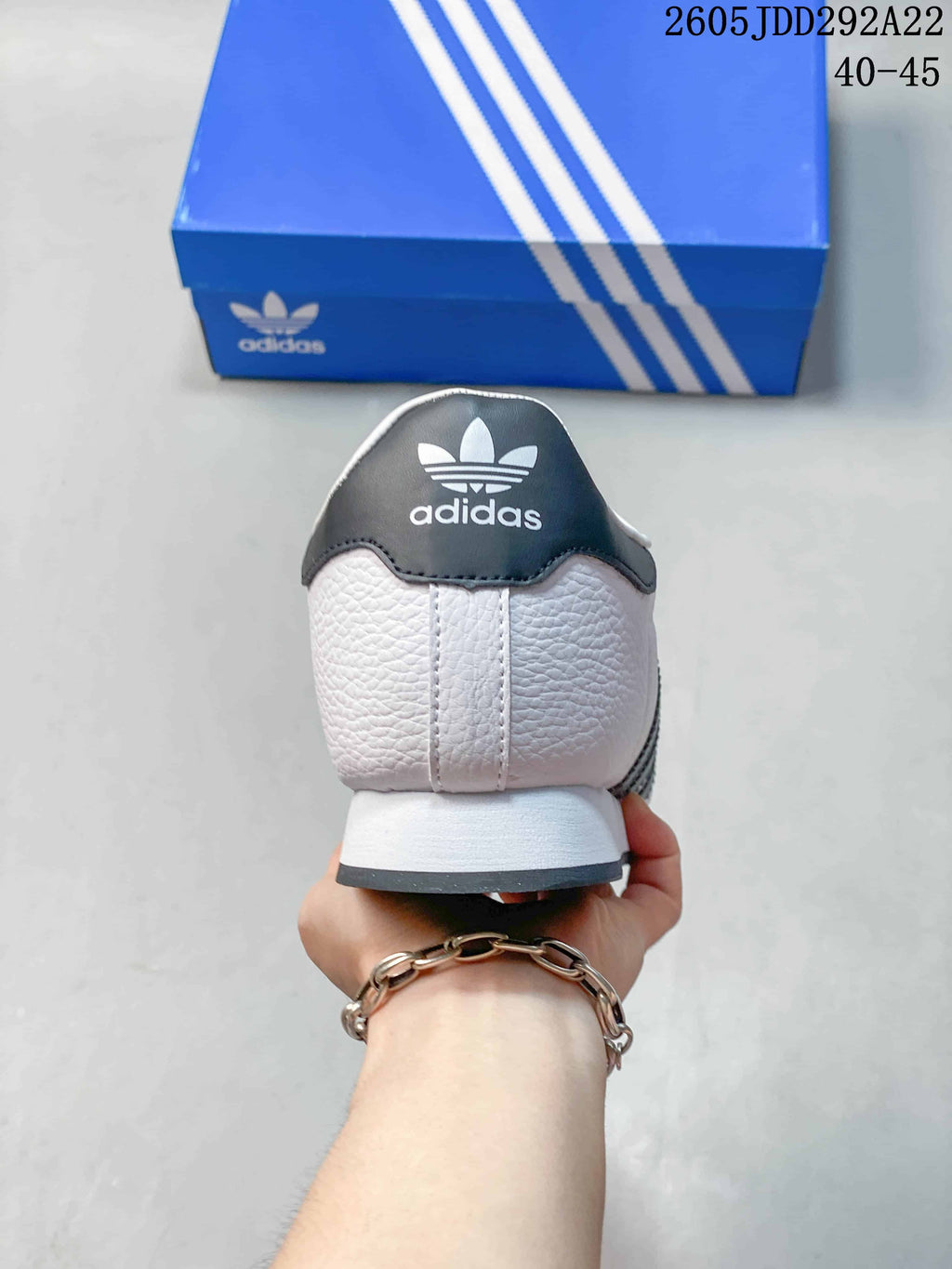 Rear view of a white Adidas Samoa sneaker with a dark heel panel