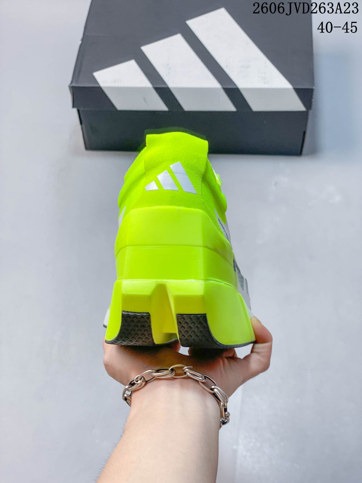 Rear view showing the neon-yellow heel, raised sole and dark outsole.