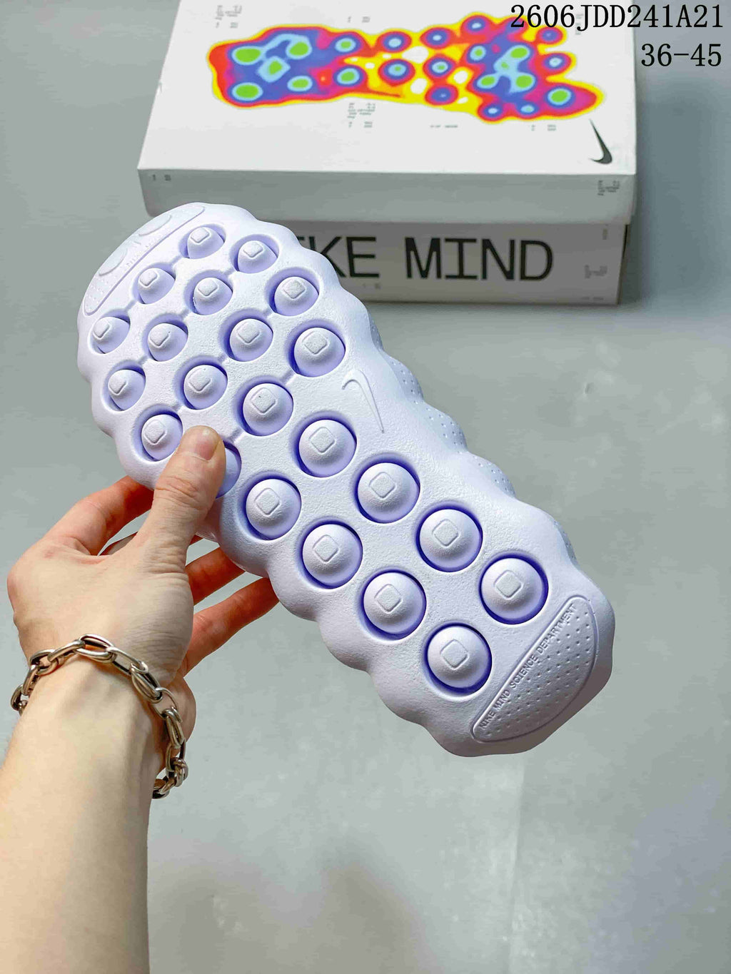 Close-up of the outsole showing circular raised elements and the Nike Mind box