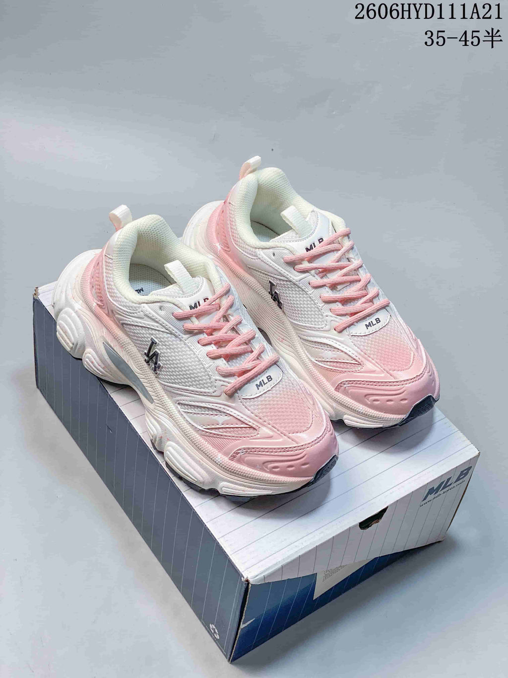 Pair of white and pink MLB NY chunky sneakers shown on a shoebox.