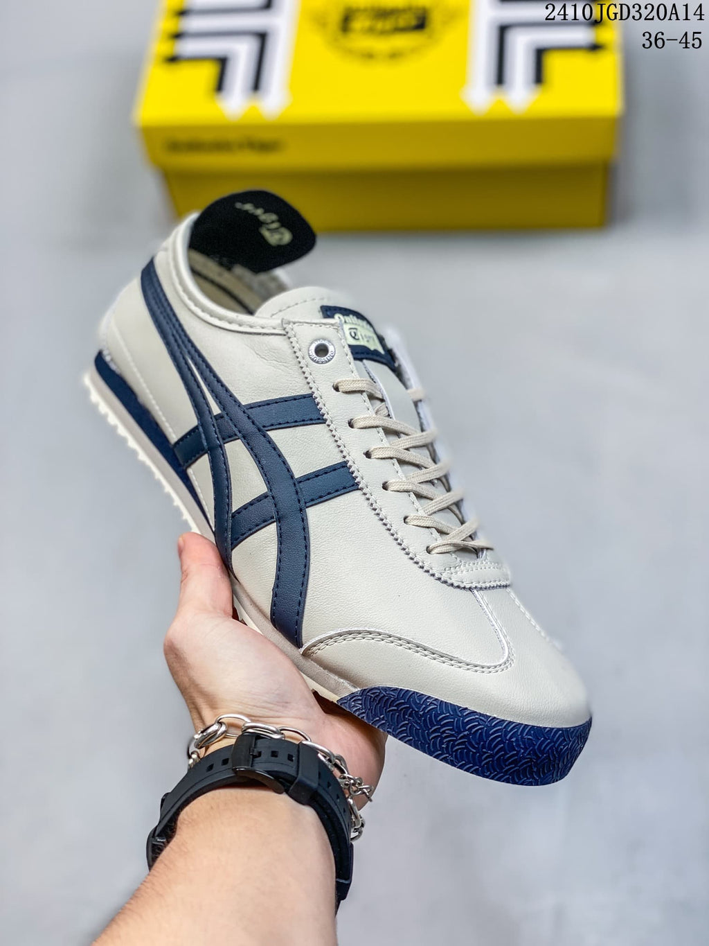 White low-top sneaker with navy side stripes and navy toe outsole