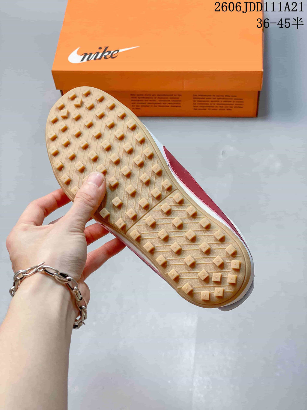Underside of a sneaker showing a gum-colored outsole with raised stud-like tread