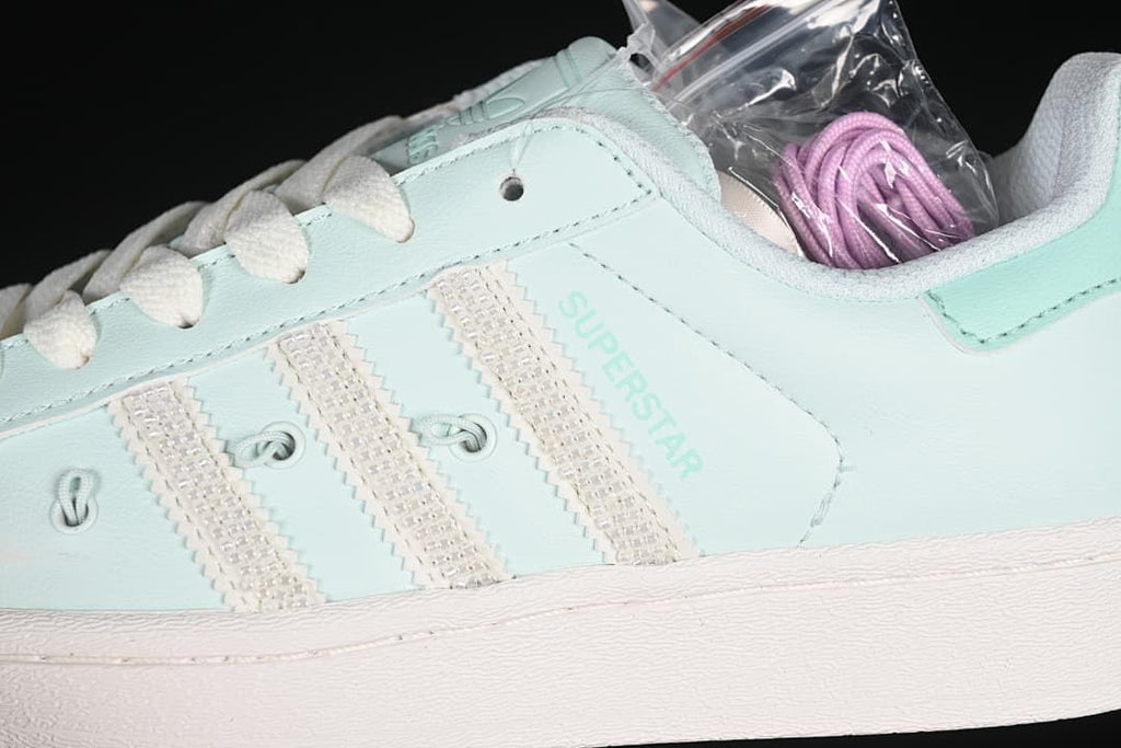 Close-up of mint upper, textured side stripes, and pink spare laces