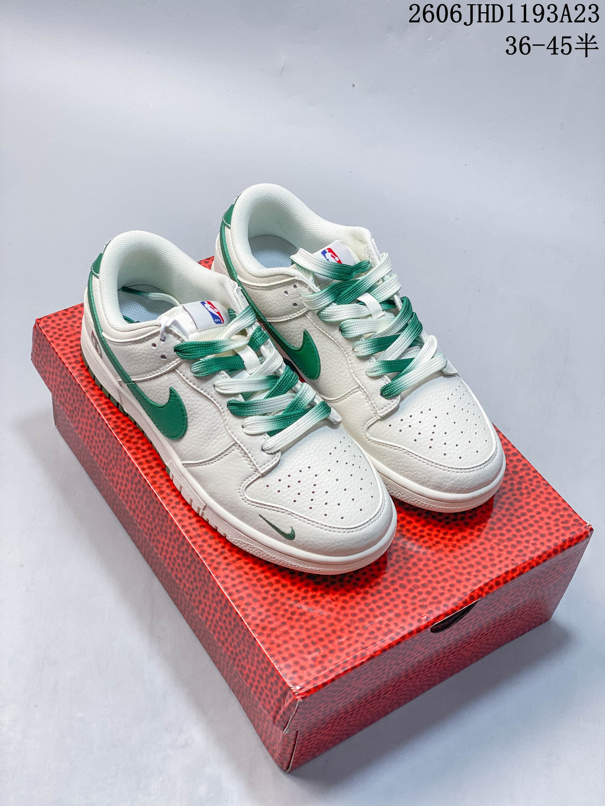 Pair of white and green Nike SB Dunk Low sneakers on a red NBA-branded box