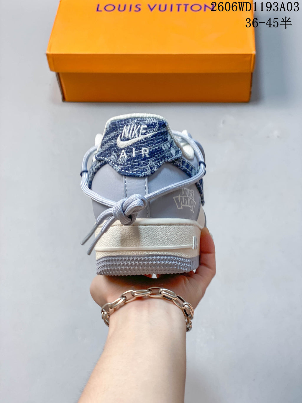 Rear view of the sneaker showing a blue patterned heel tab, gray overlays, and white midsole.