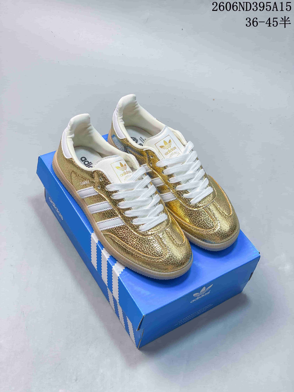 Pair of gold-tone metallic low-top sneakers with white stripes and laces