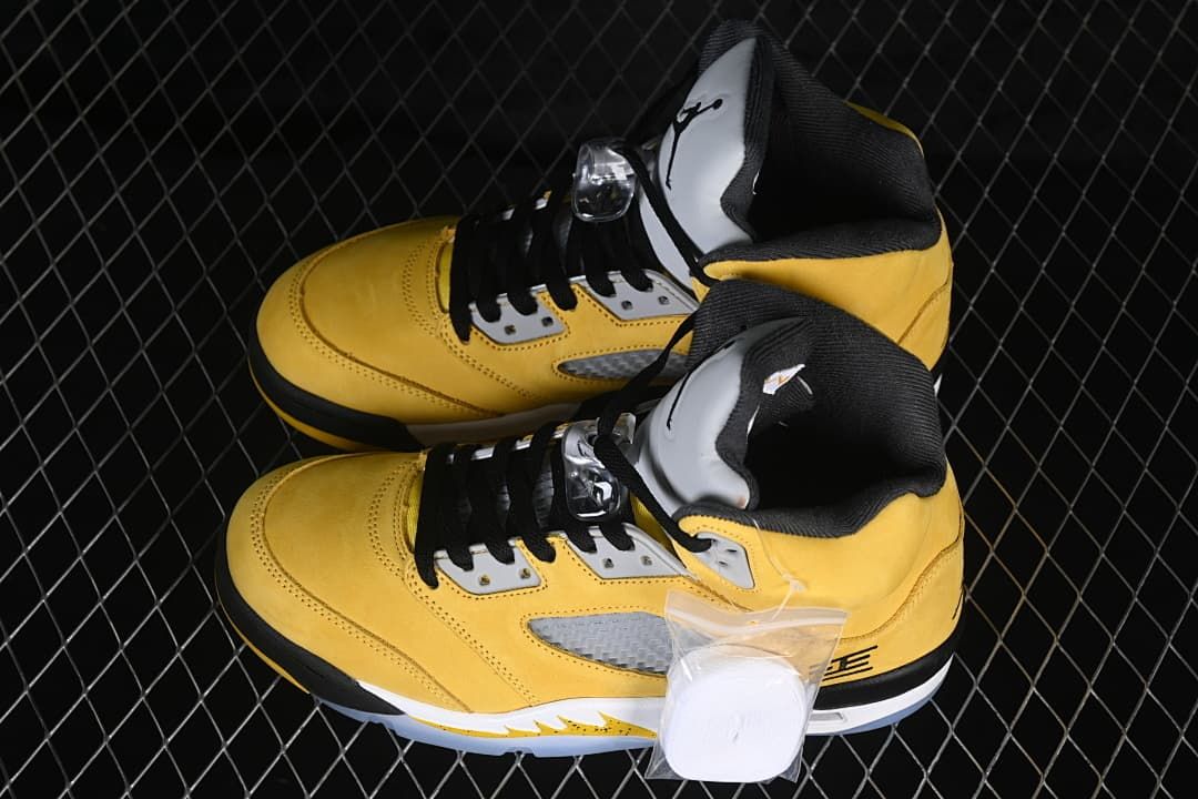 Pair of yellow and black high-top sneakers with a small accessory bag