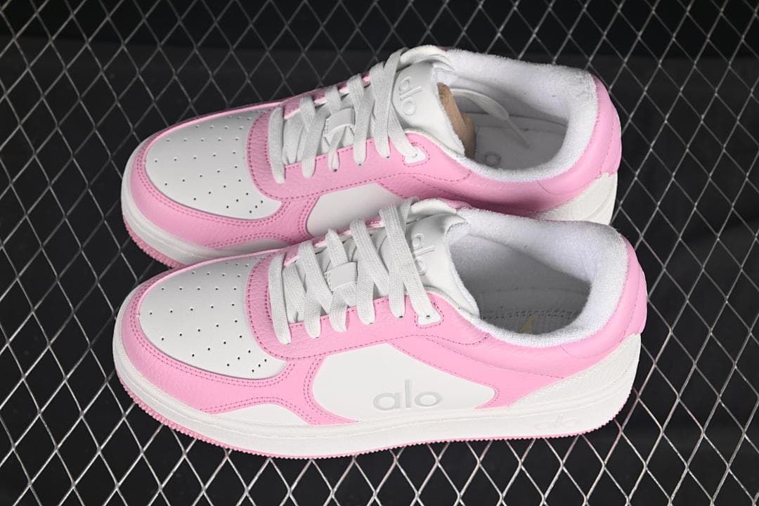 Pair of pink and white low-top sneakers viewed from above