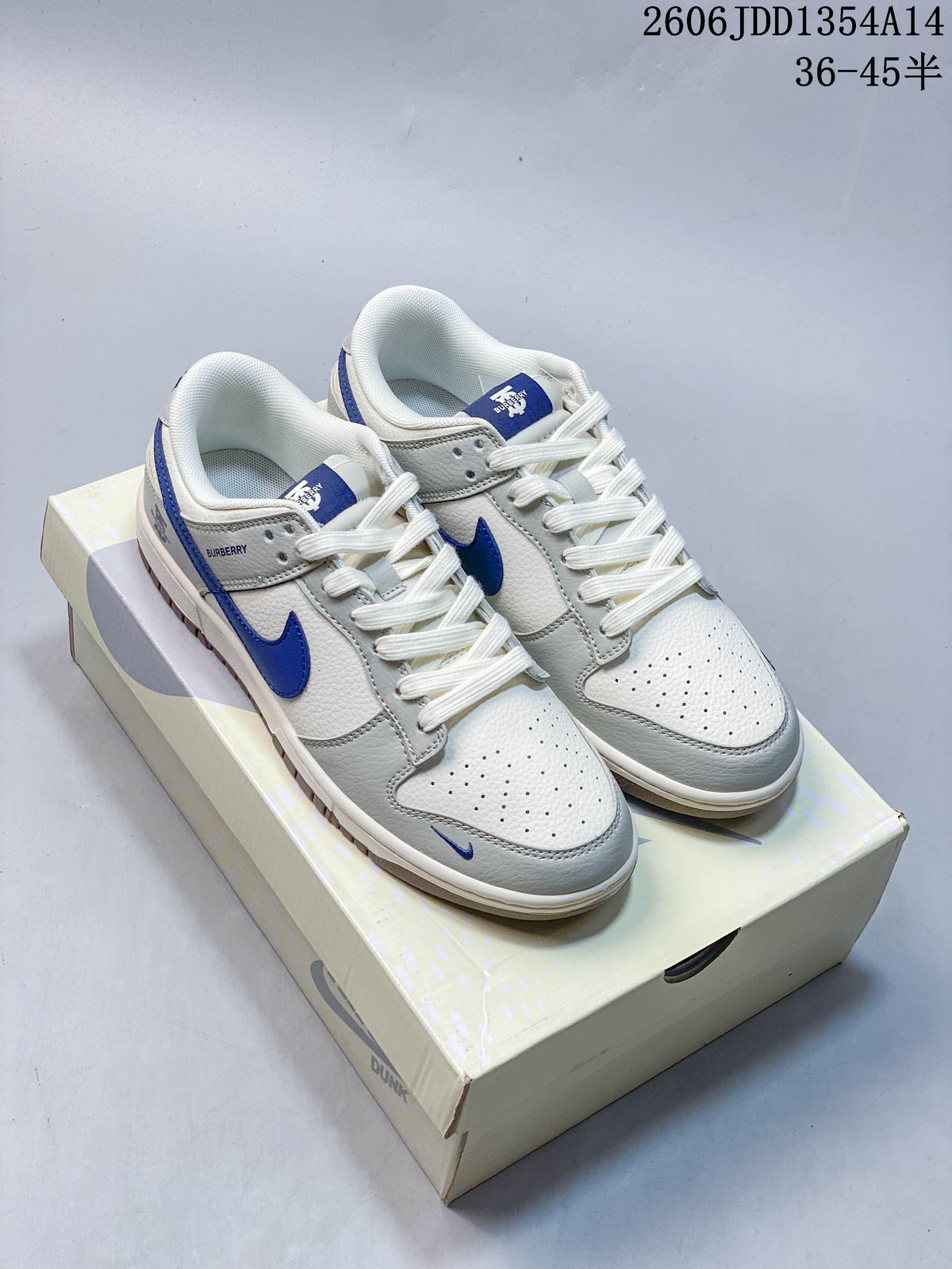 Pair of white and grey low-top sneakers with blue Swoosh details on a Nike Dunk box