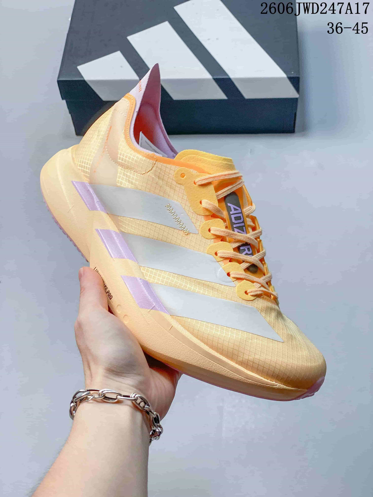 Side profile of the pale yellow running shoe with silver stripes and pink-lavender details.