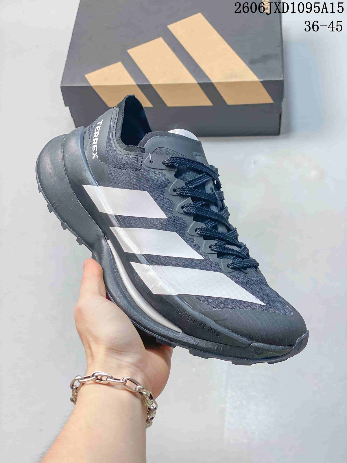 Side view of a charcoal Adidas Terrex shoe with white stripes