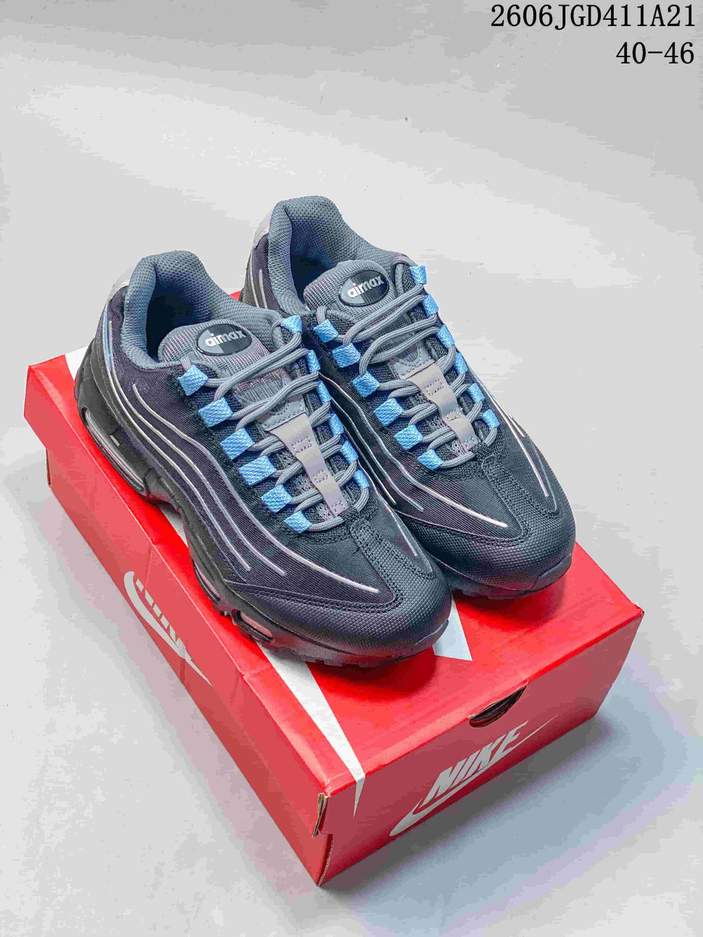 Pair of charcoal-gray Nike Air Max 95 sneakers with blue accents on a red shoebox; image text lists EU sizes 40–46.
