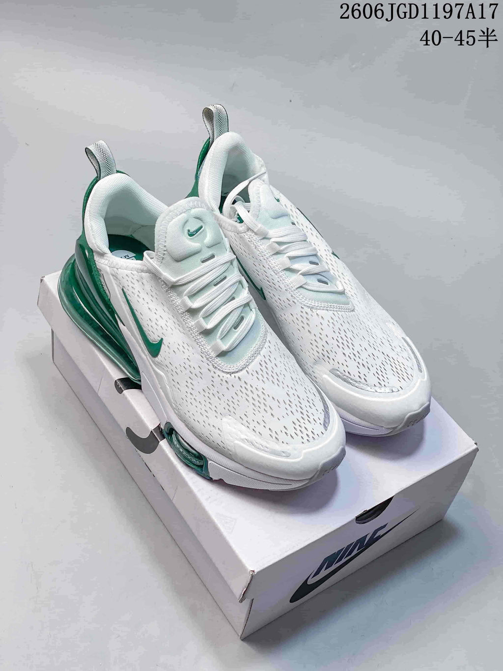 Pair of white Nike Air Max Pulse shoes with green accents.