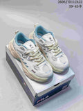 Pair of white and light blue FILA retro sneakers with cream-colored soles on a shoebox.