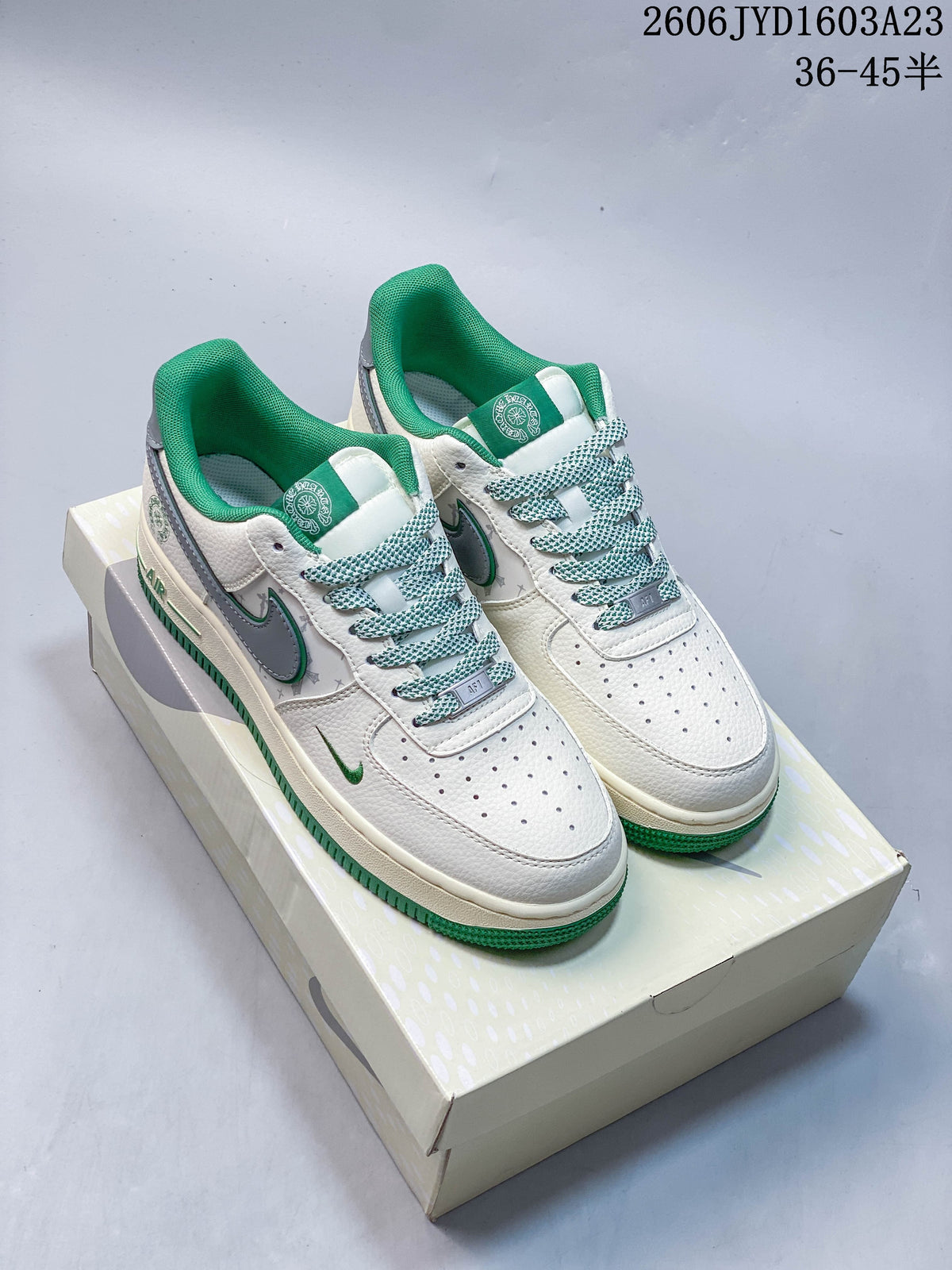 Pair of white low-top sneakers with gray side panels, green accents, patterned laces, and green collars.