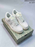 Pair of white Nike Air Force 1 low-top sneakers with pale gray accents on a patterned box; image displays style code and size range.