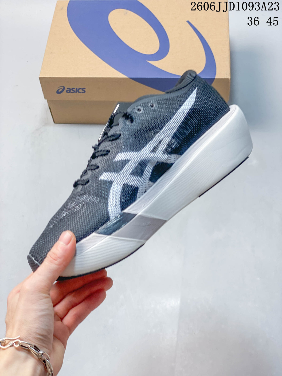 Side profile of the gray running shoe with white side stripes and a sculpted white midsole.