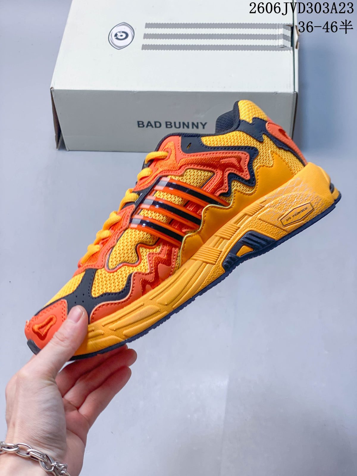 Side view of the yellow, orange, and navy low-top sneaker