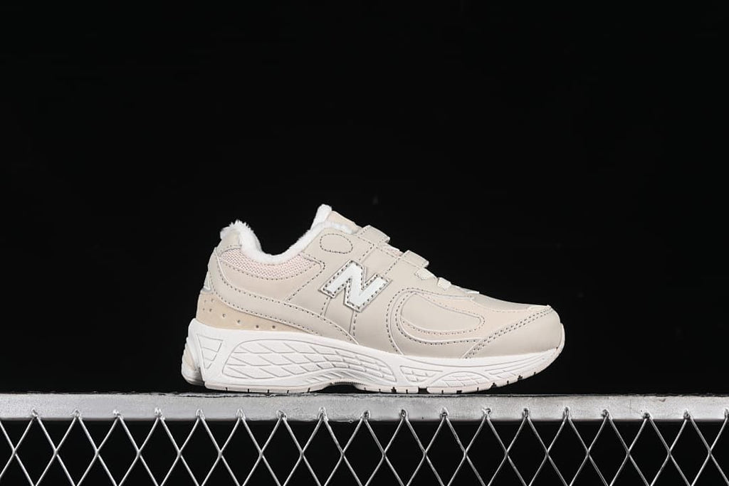 Side profile of one light beige sneaker with a white sole and fluffy collar lining