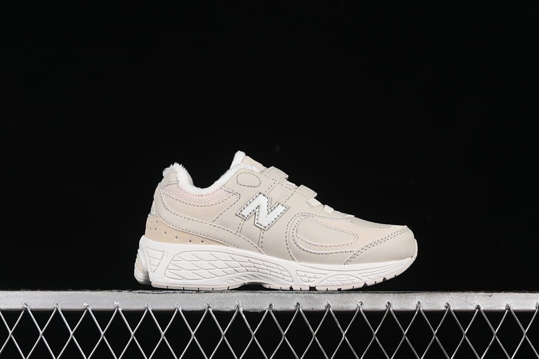 Side profile of one light beige sneaker with a white sole and fluffy collar lining