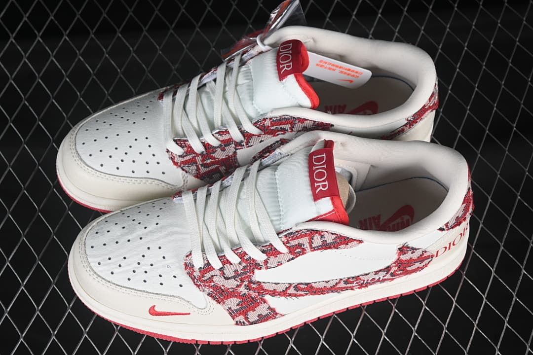 Top view of a pair of cream-and-red low-top sneakers with patterned overlays and white laces
