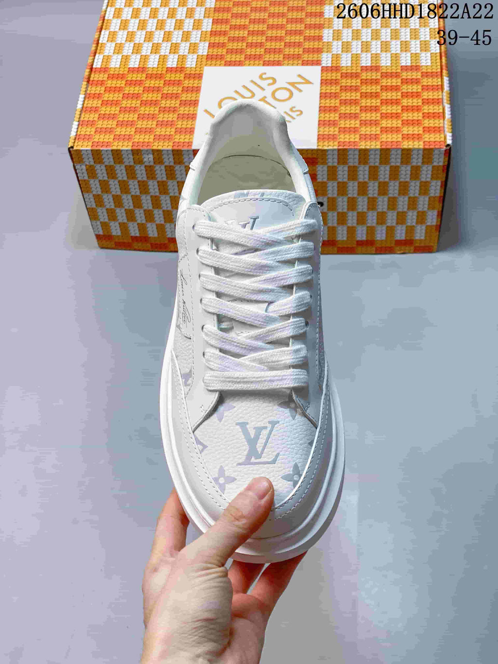 Top view of a white lace-up sneaker with multicolored monogram-style patterning