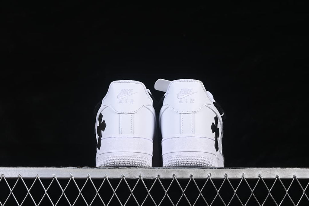 Rear view of both white sneakers with black side details.