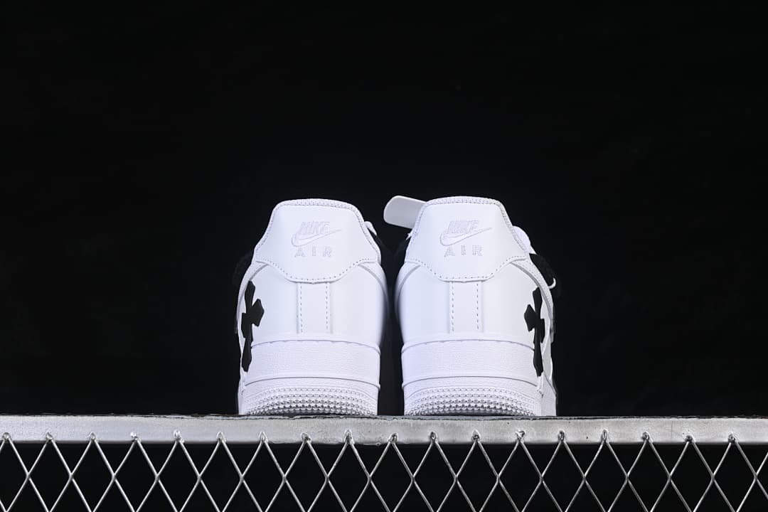 Rear view of both white sneakers with black side details.