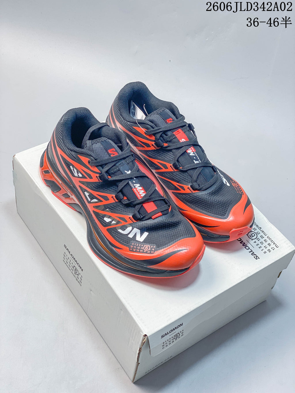 Pair of navy and orange Salomon trail running shoes on a shoe box.