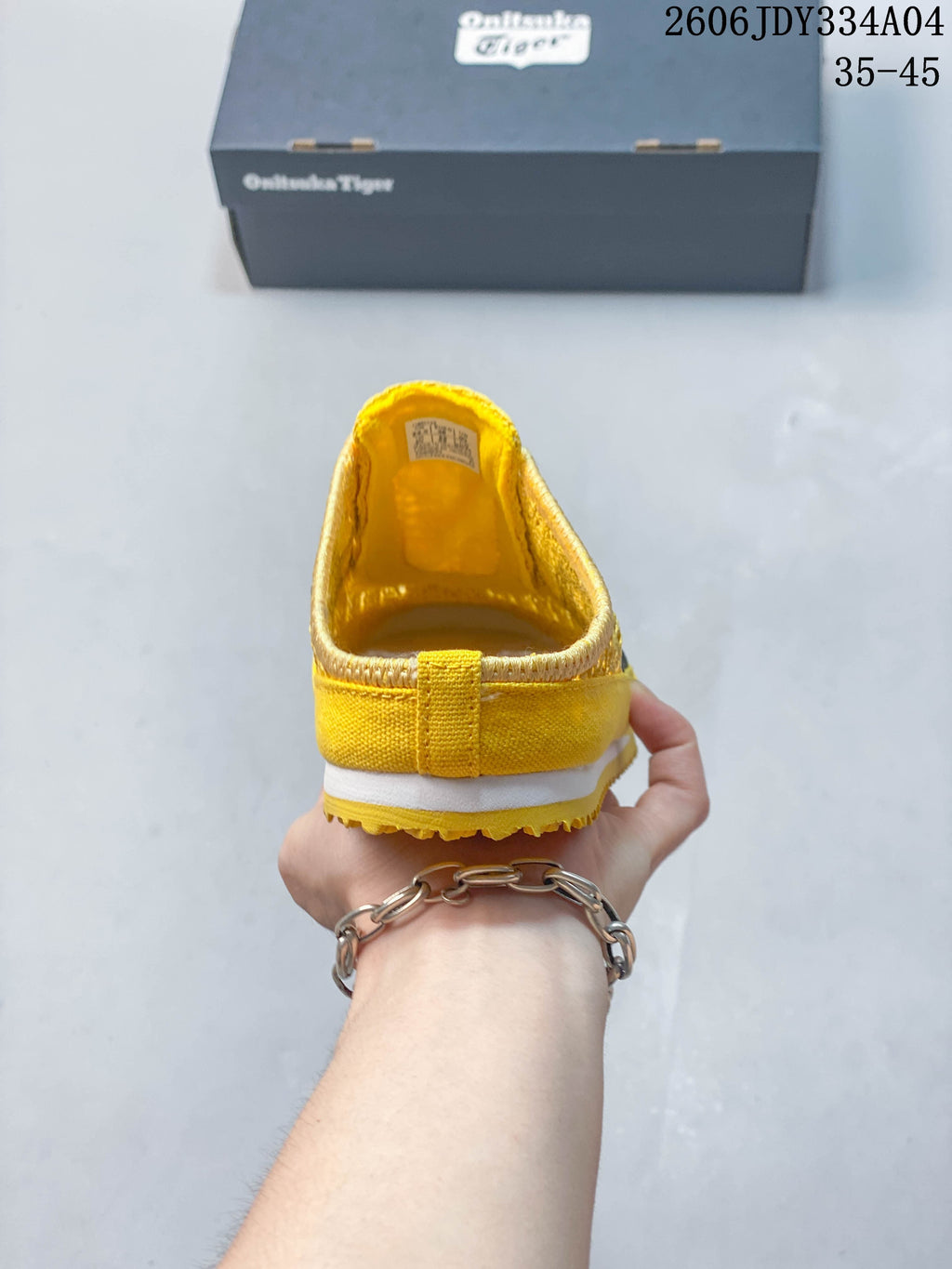Rear view showing the open heel and yellow upper of the Sabot slip-on.