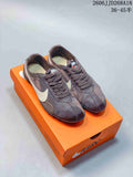 Pair of brown Nike Moon Shoe OG Summit low-top sneakers with light-colored Swooshes, shown on an orange box.