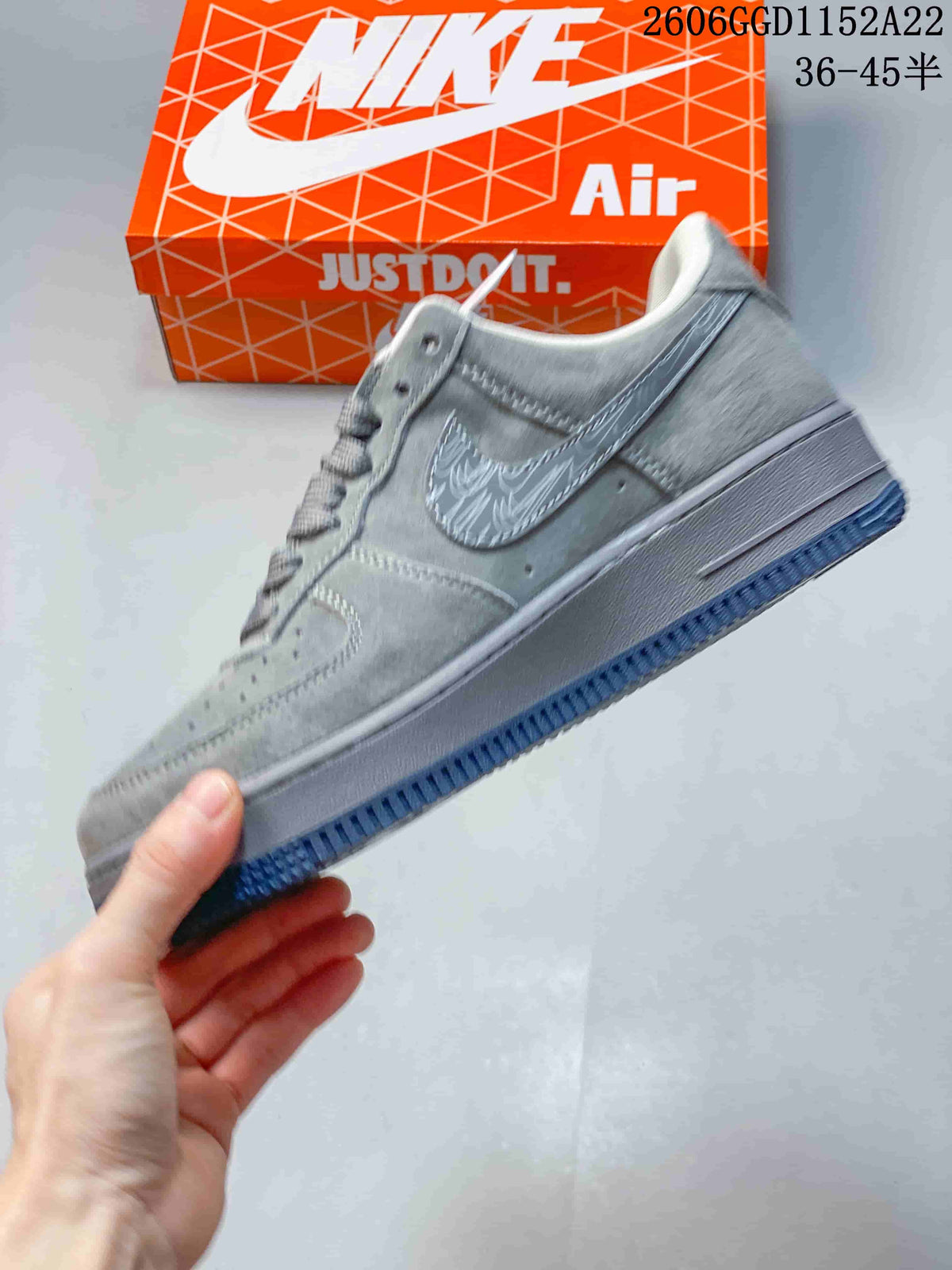 Side view of a grey low-top sneaker with a patterned Swoosh and dark blue outsole